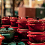 Colorful ceramic cookware set with stacked pots and pans in a kitchen store display