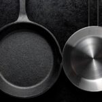 Cast iron skillet and stainless steel pan side by side on dark background comparison