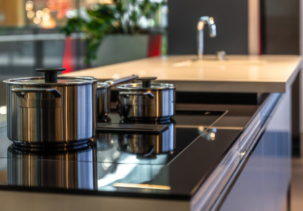 Stainless steel pots and pans on a glass top stove