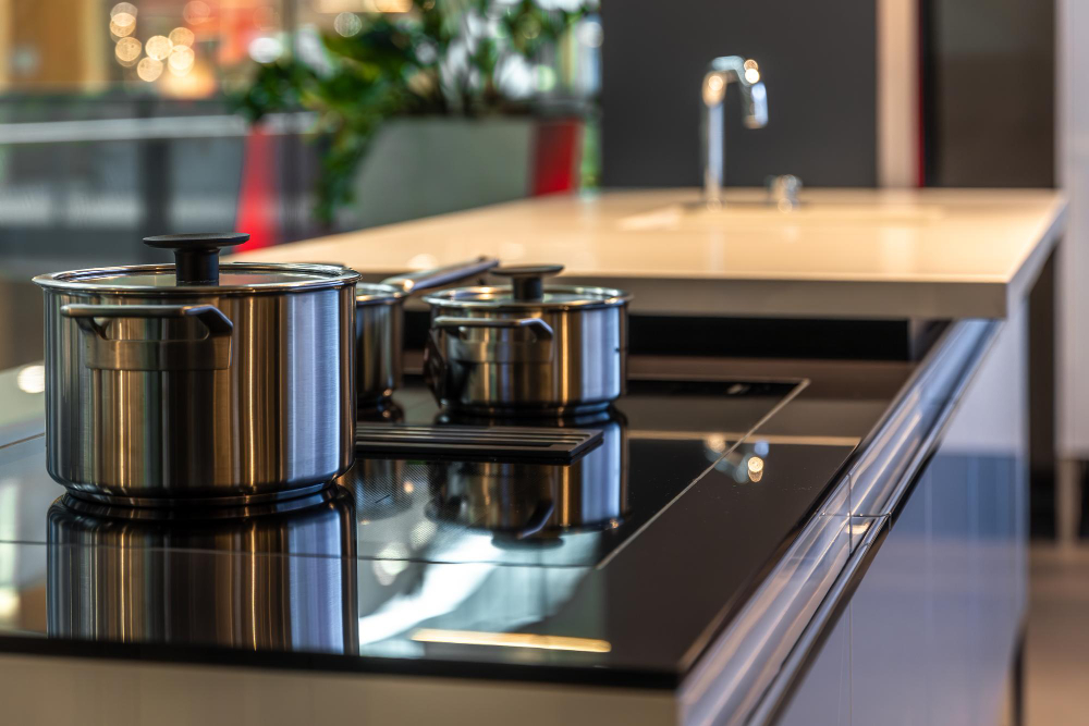Stainless steel pots and pans on a glass top stove